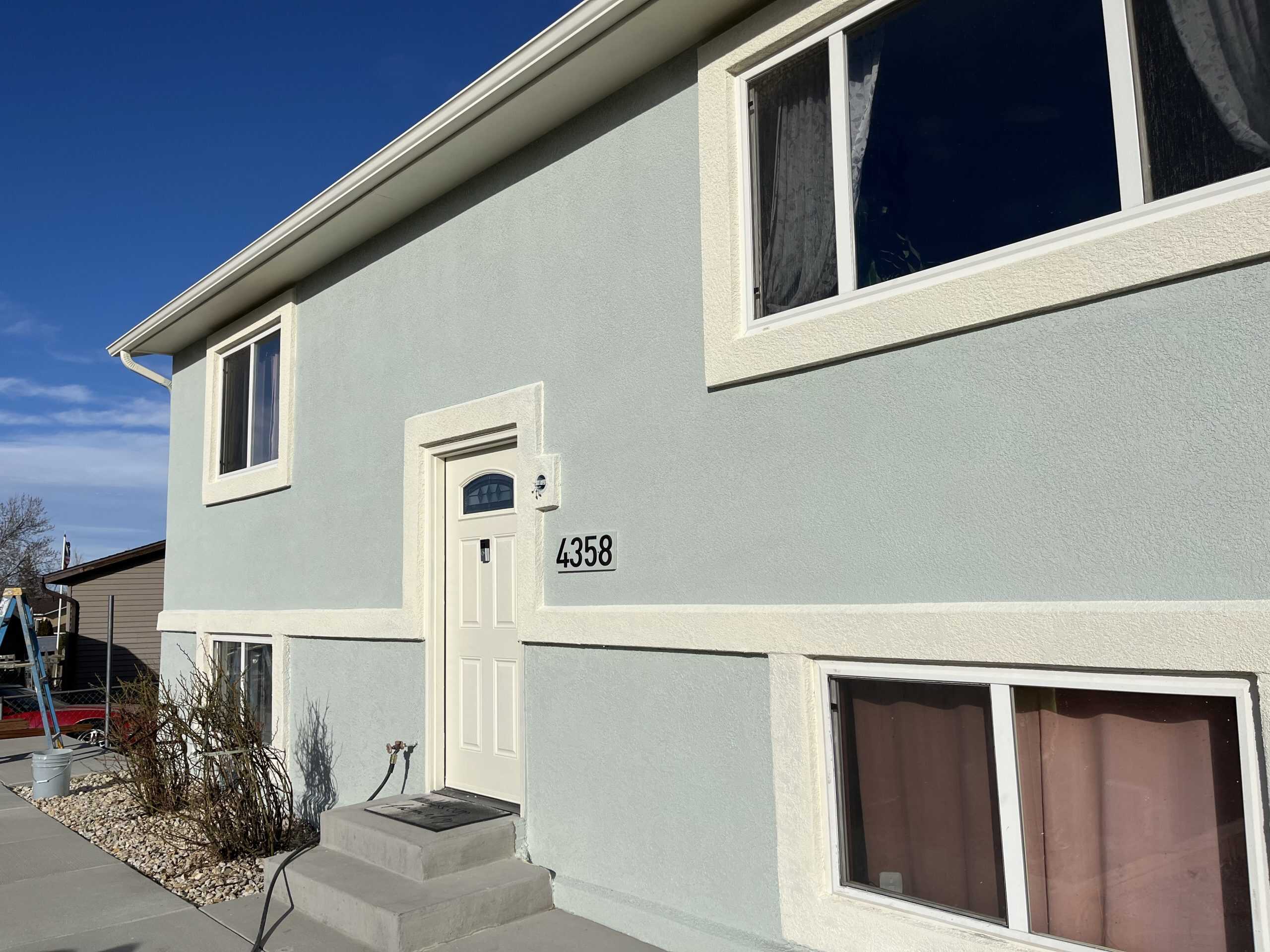 Exterior house painting Colorado Springs – stucco home with light blue walls and white trim